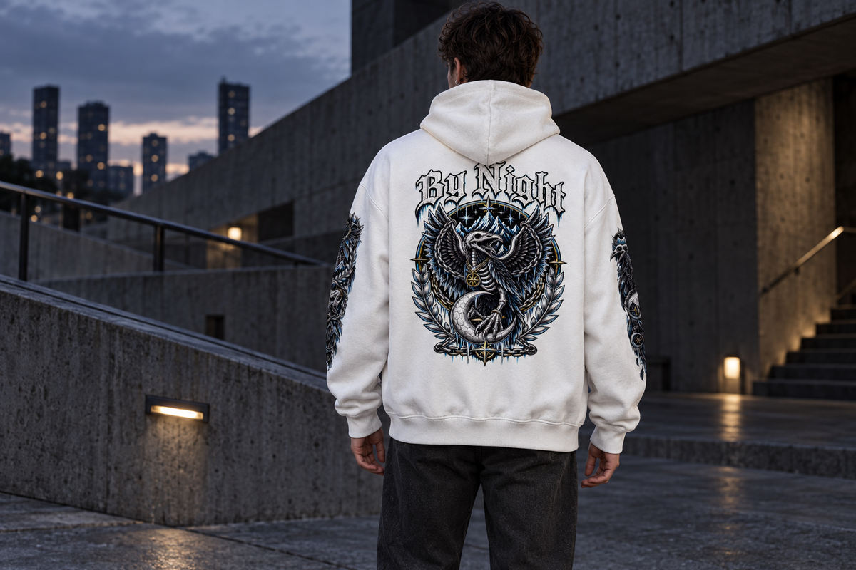 Rear view of a white By Night RavenFall oversized hoodie with raven and crescent back artwork and printed sleeves.